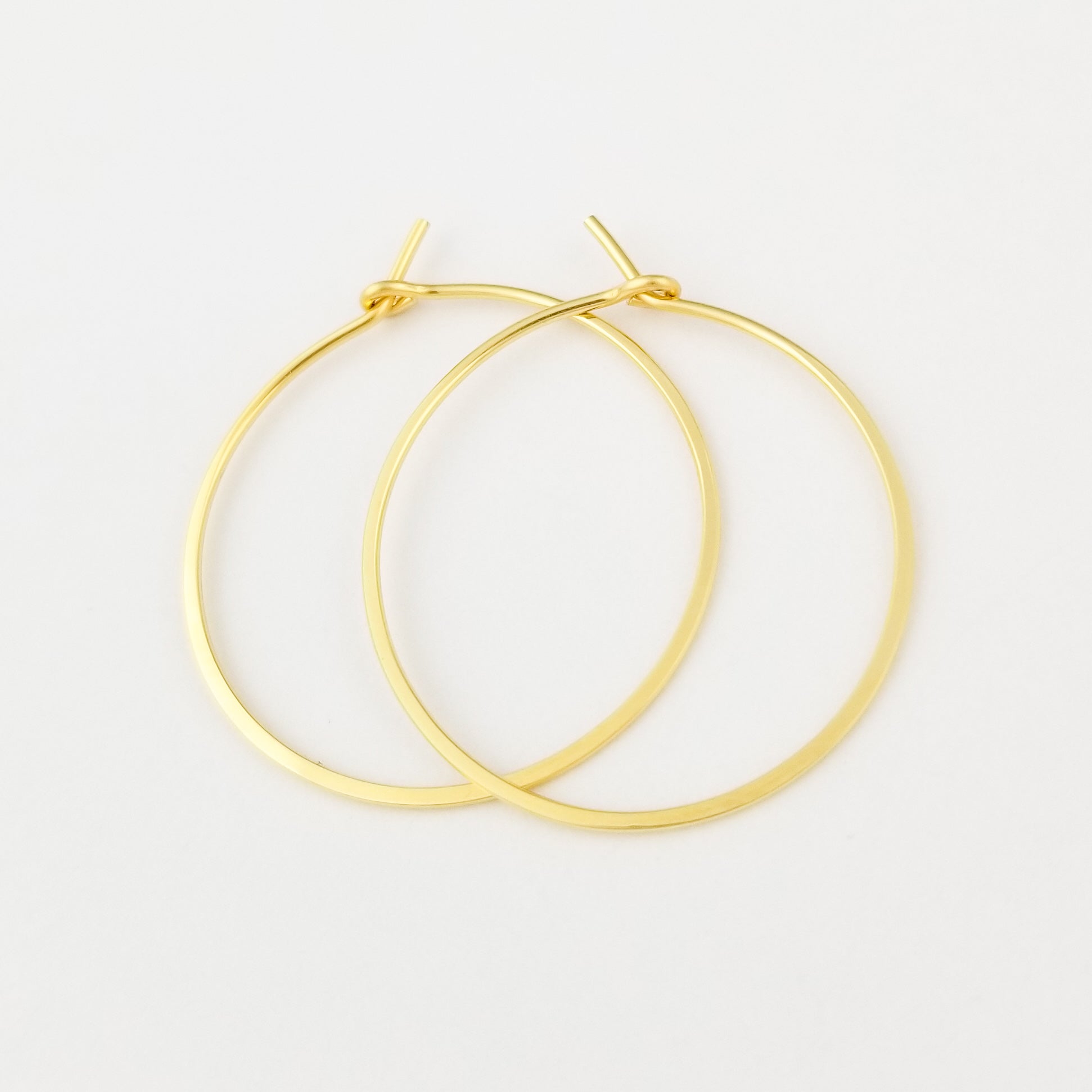 Thin Flat Hammered Gold Hoops Handmade with Solid 18 Karat Yellow Gold on White Background