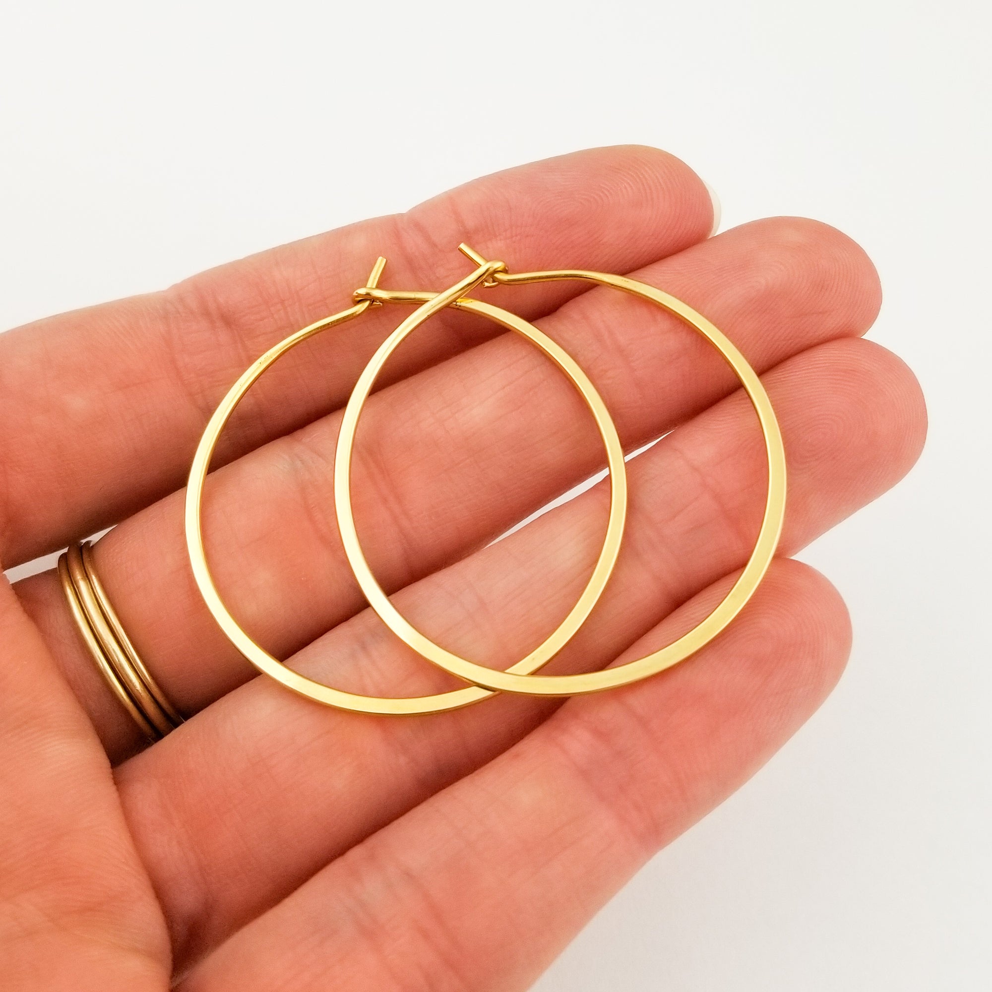 Solid 22 Karat Yellow Gold Flat Hammered Hoop Earrings One and One Half Inch Extra Thick on Black Rock