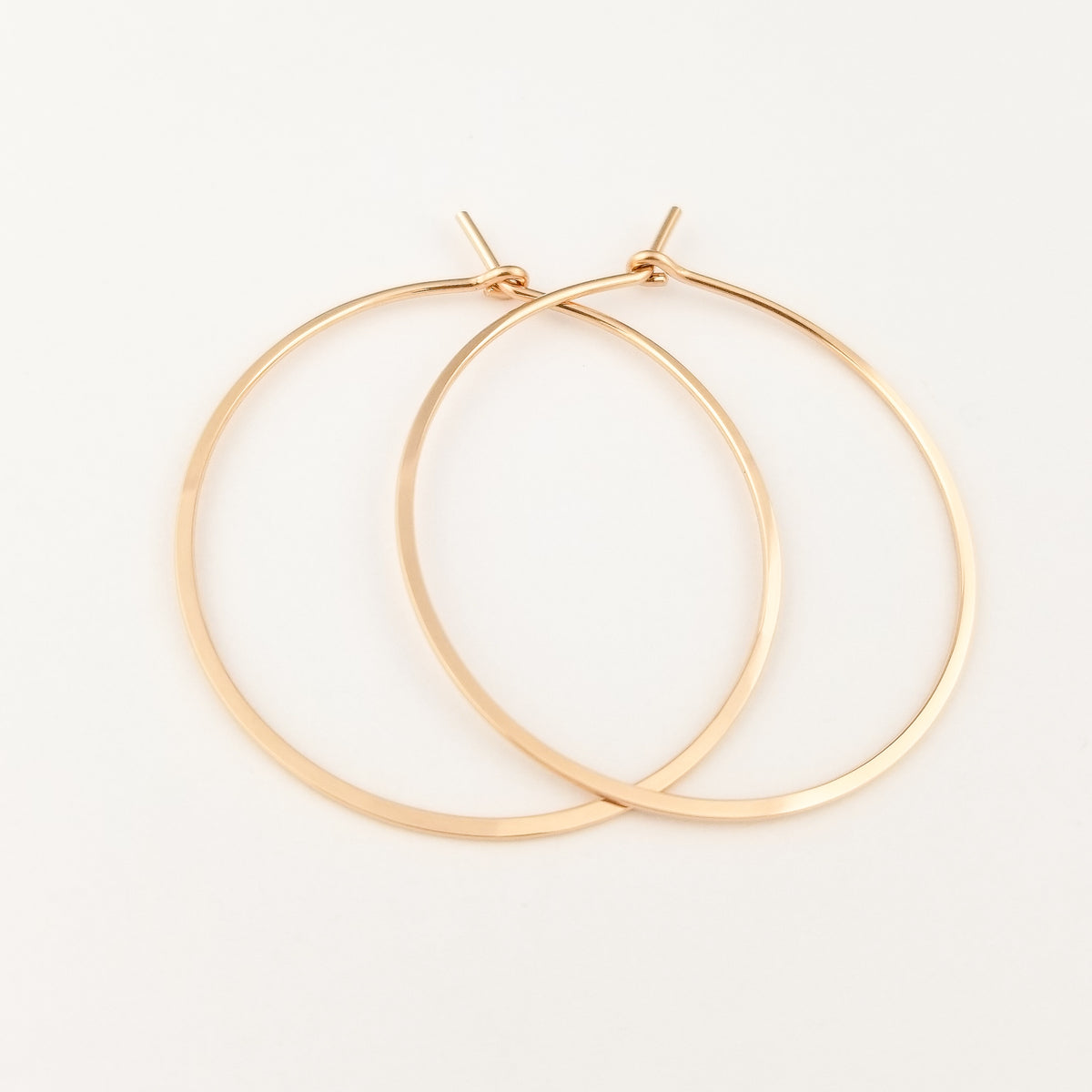 Flat Hammered Gold Hoops in Solid 14 Karat Rose Gold on White Background