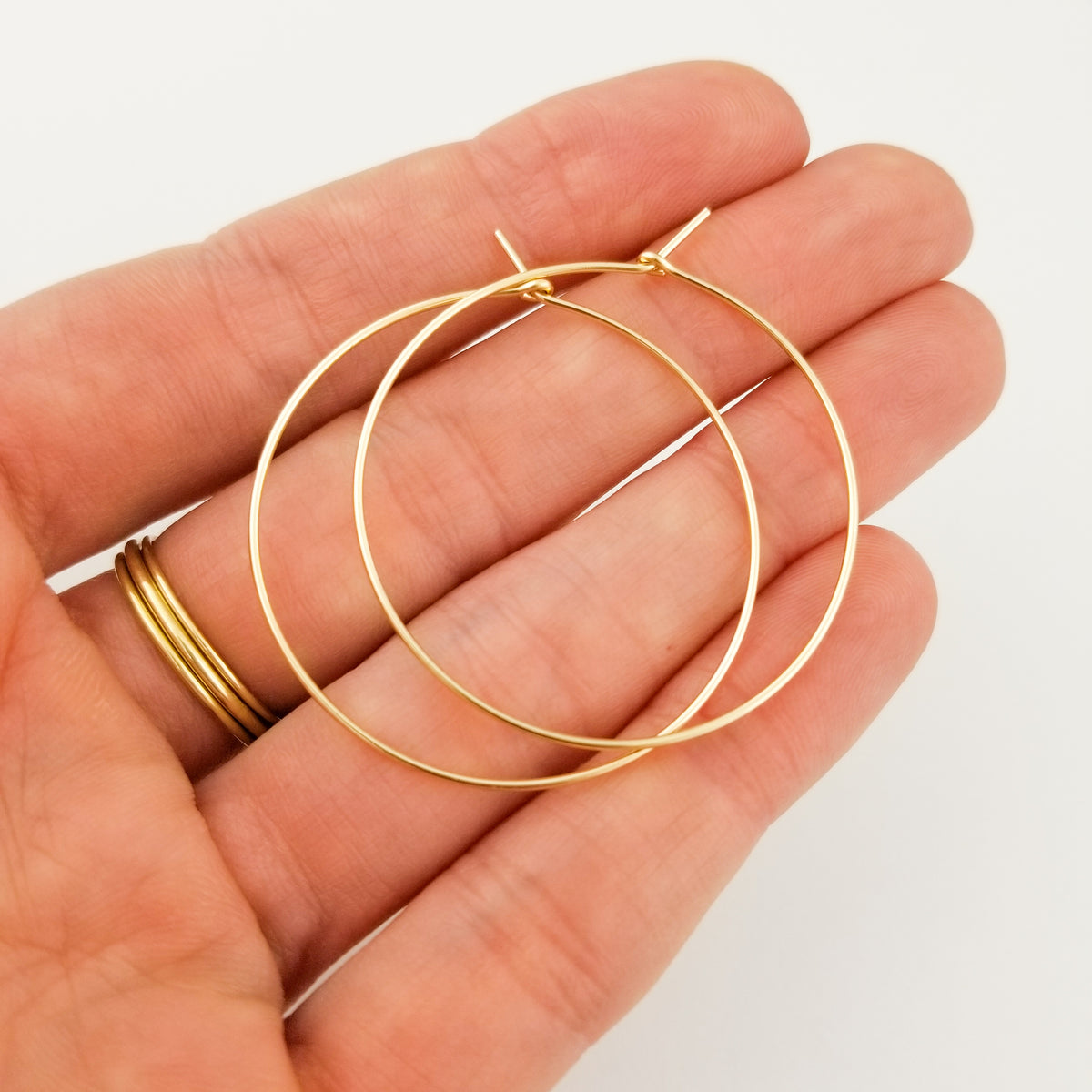 Gold Hoop Earrings 14k Yellow Gold Earrings One and a Half Inch Thin Classic Hoops held in Hand