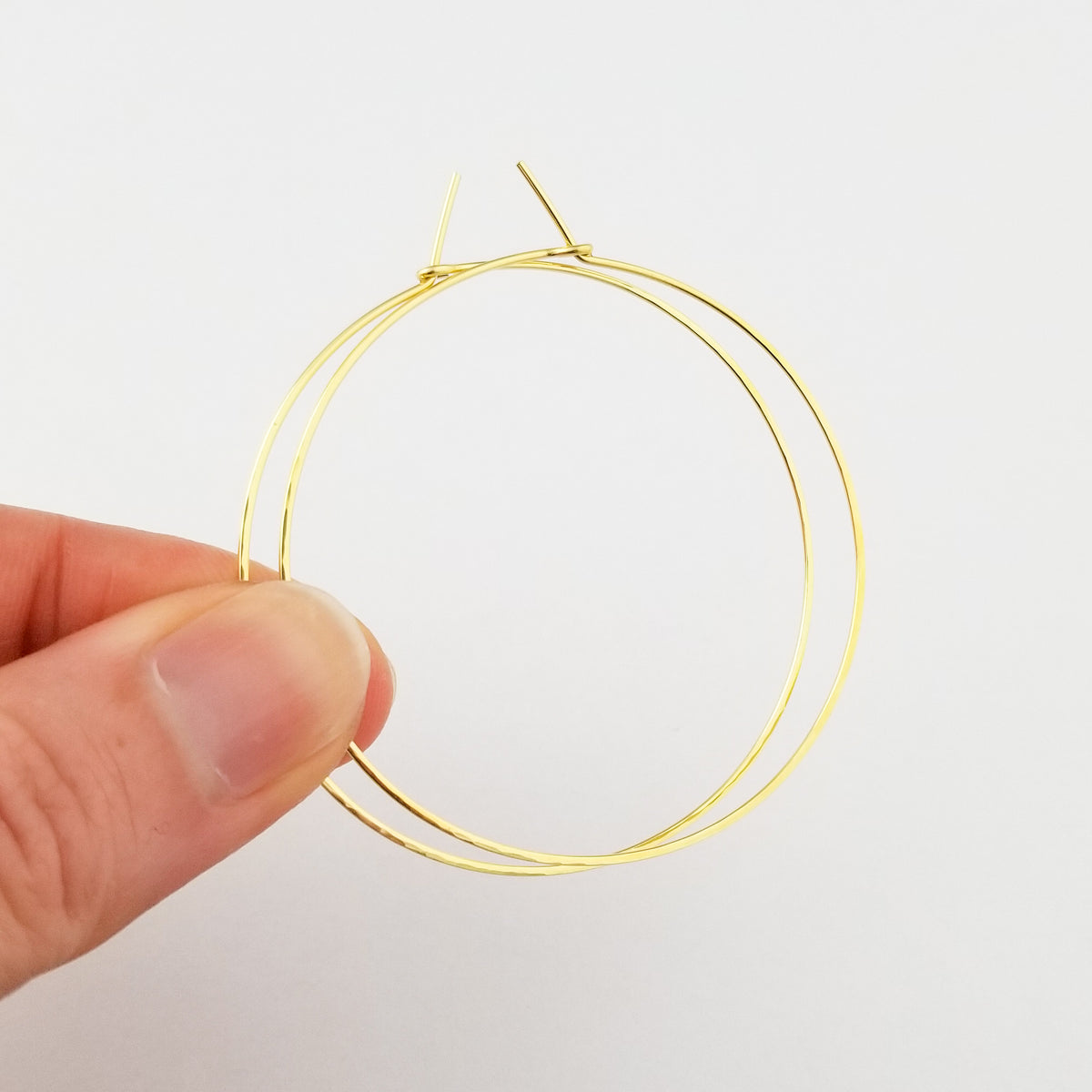 Gold Hoop Earrings Handmade from Thin Solid Yellow Gold Metal Wire Lightly Hammered held in Fingers