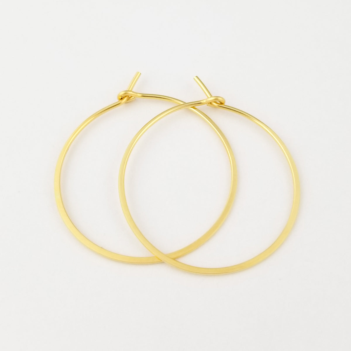Thin Flat Hammered Gold Hoops Handmade with Solid 18 Karat Yellow Gold on White Background
