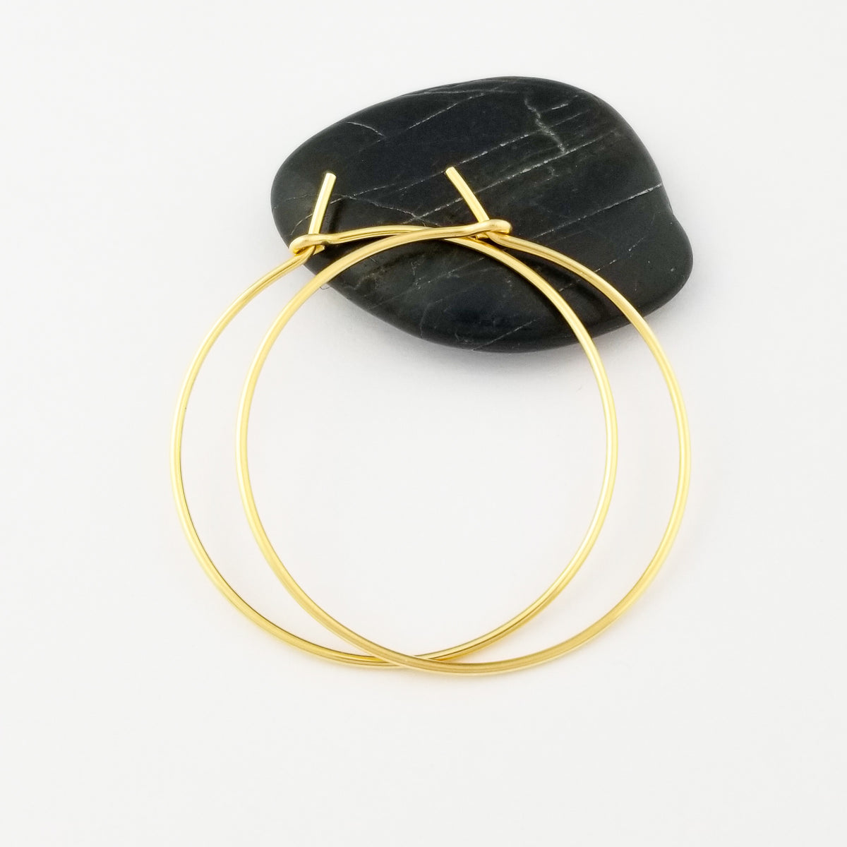 Gold Hoop Earrings in Solid Yellow 14 Karat Gold Thick Classic Style on Black Rock