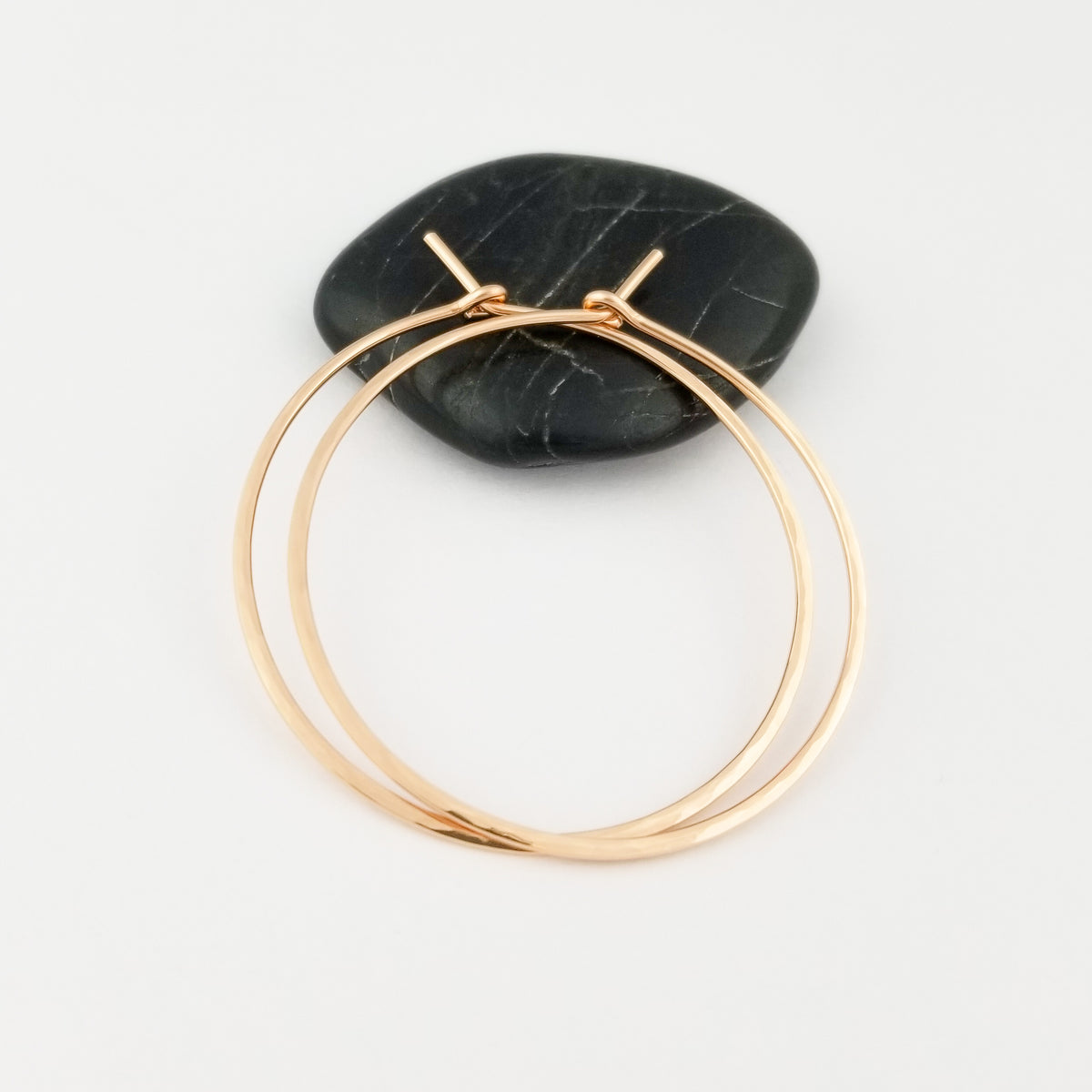 Solid 14k Rose Gold Thick Hammered Gold Hoop Earrings on Black Rock