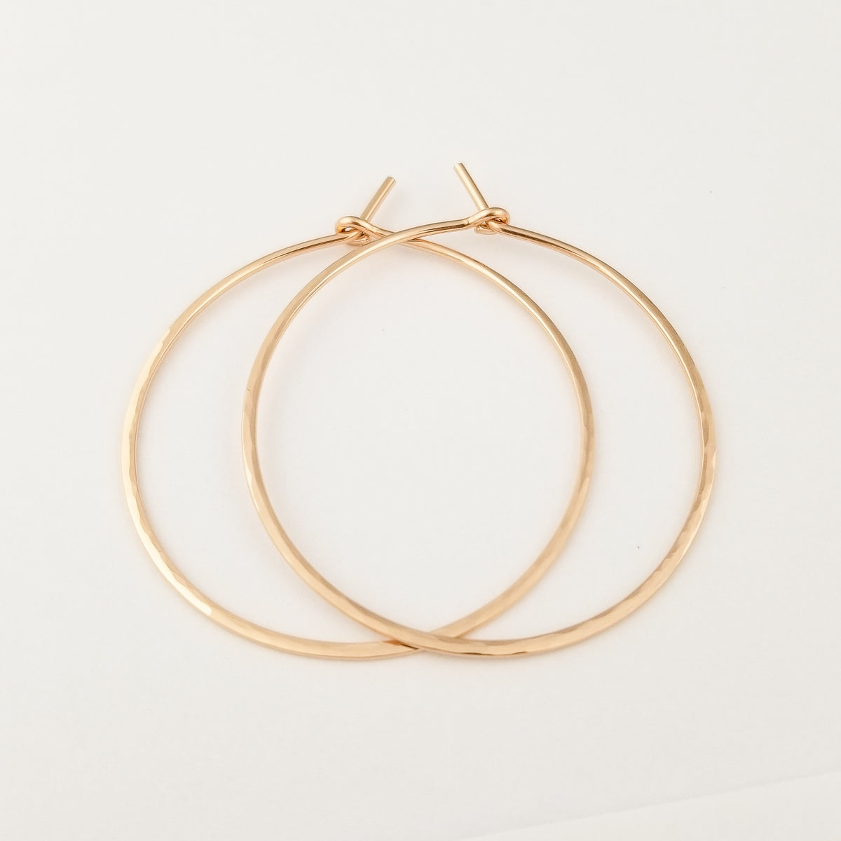Rose Gold Hammered Hoop Earrings in Solid 14k Rose Gold Thick Metal Wire on White Background