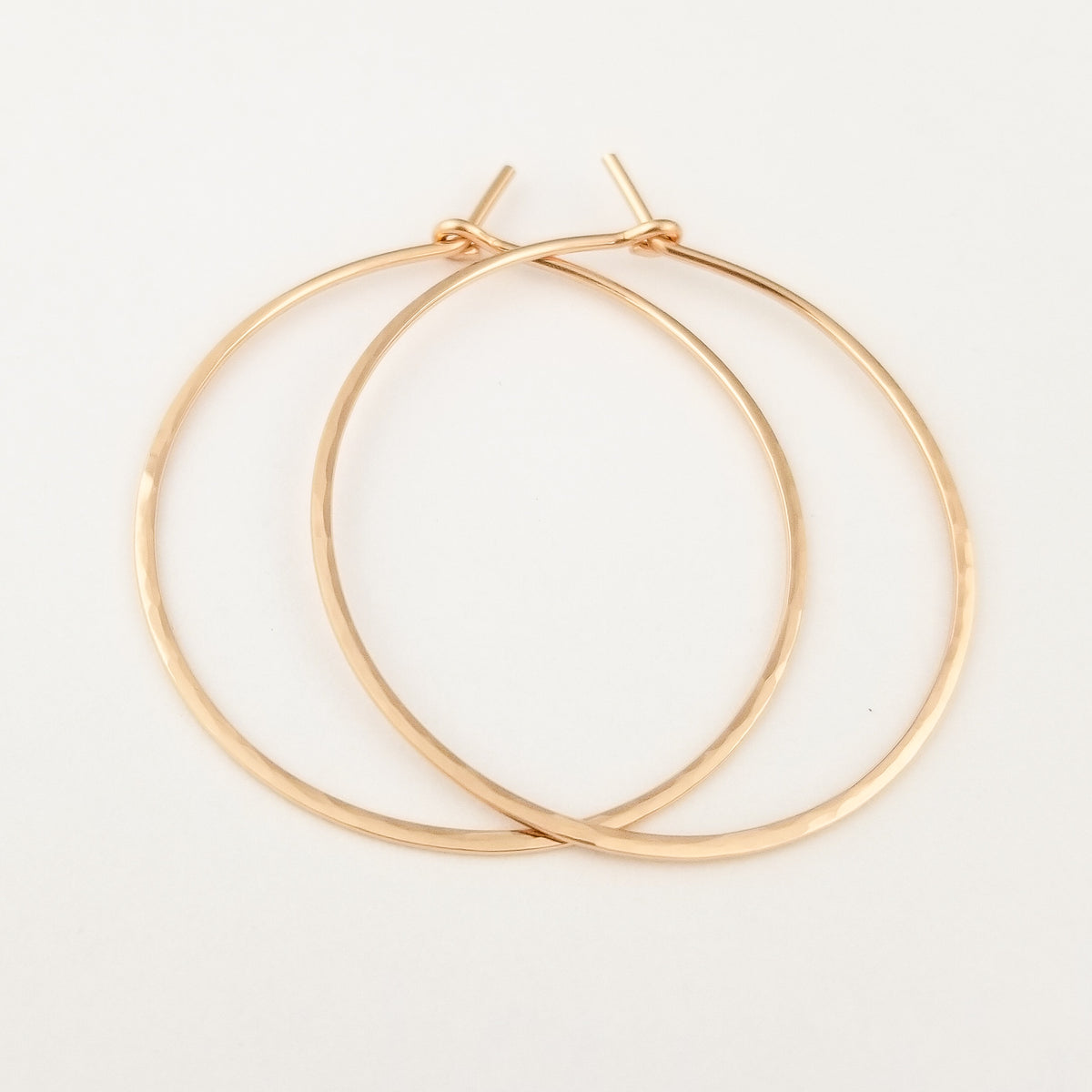 Rose Gold Hammered Hoop Earrings in Solid 14k Rose Gold Thick Metal Wire on White Background
